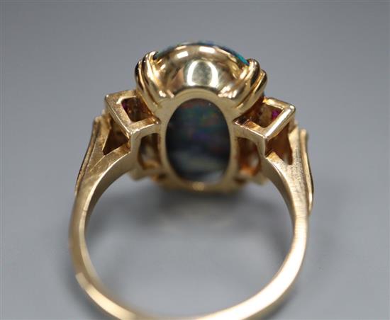 A 1930s/1940s yellow metal, oval black opal, ruby and diamond set dress ring, size O/P, gross 6.8 grams,